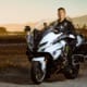 Police officer on motorcycle at sunset with amusement park in the background.